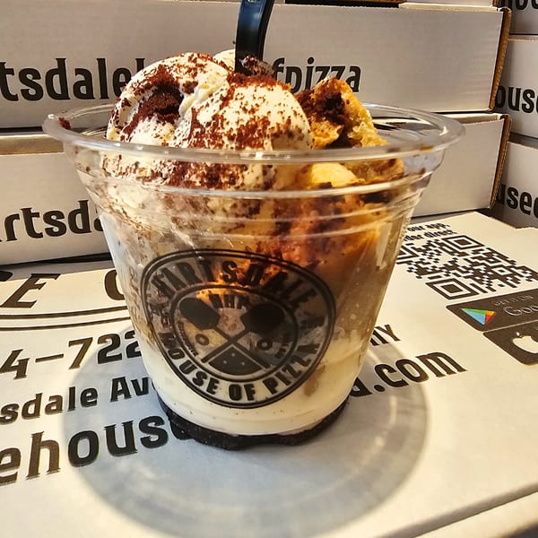 Tiramisu dessert cup with whipped cream and cocoa powder, featuring the Hartsdale House of Pizza logo.
