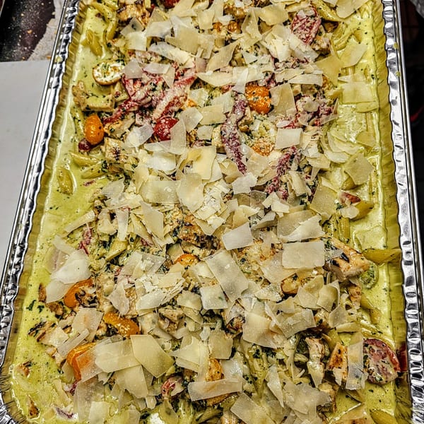 Penne pasta with chicken, sun-dried tomatoes, and parmesan cheese in a creamy pesto sauce.