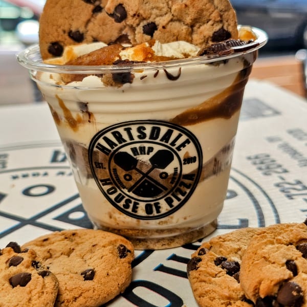 Hartsdale House of Pizza branded milkshake with chocolate chip cookies on a pizza box.