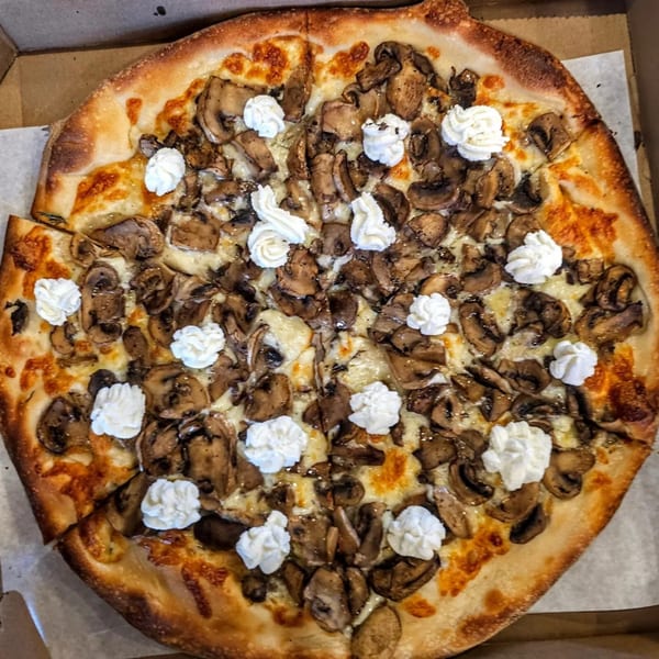 Hartsdale House of Pizza mushroom pizza with dollops of ricotta cheese in a pizza box.