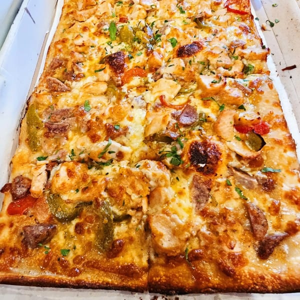 Hartsdale House of Pizza's rectangular pizza with chicken, peppers, and melted cheese in a box.
